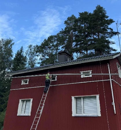 Kokenut asentaja nostaa yhtenäistä ränniä paikoilleen